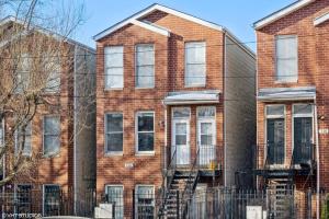 a brick building with a fence in front of it at 2-Bed 2-Bath Apt - Close to UC w/ Free Parking in Chicago
