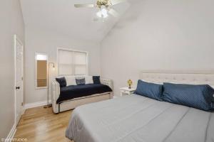 a white bedroom with a bed and a chair at 2-Bed 2-Bath Apt - Close to UC w/ Free Parking in Chicago
