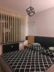 una camera da letto con un letto con un piumone bianco e nero di Aparthouse Zegrze a Serock