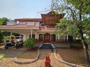 a house with a red fire hydrant in front of it at Dream Palace in Alleppey