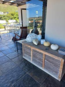 a wooden dresser with a mirror on a patio at Whale Rock Guest House in Plettenberg Bay