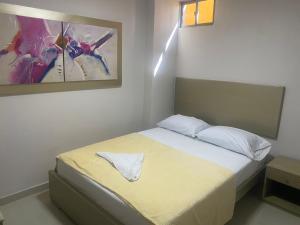 a bedroom with a bed and a painting on the wall at HOTEL DASANTO HD in Barranquilla