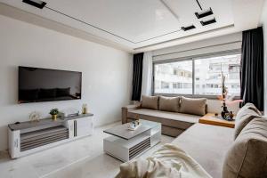 a living room with a couch and a tv at Élégant appart tanger boulevard in Tangier