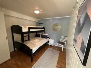 スヴォルヴァールにあるLofoten Rorbuerの小さな客室で、二段ベッド1組、椅子が備わります。