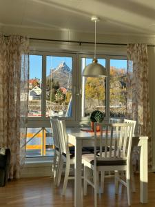 a dining room with a table and chairs and a window at Lofoten Rorbuer in Svolvær