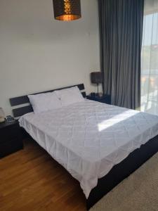 ブカレストにあるAPARTAMENT BANEASA SISESTI BY ALE 2 self check-inのベッドルーム1室(大型ベッド1台、白い掛け布団付)