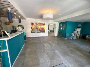 a living room with blue walls and a tile floor at Hotel La Voile in Bormes-les-Mimosas