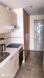 eine Küche mit Holzschränken und einem schwarzen Gerät in der Unterkunft Excelente apartamento con esplédidas vistas al mar in Puerto de la Cruz
