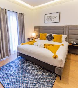 1 dormitorio con 1 cama grande con almohadas amarillas y alfombra azul en Casa Castillo, en Ciudad de México