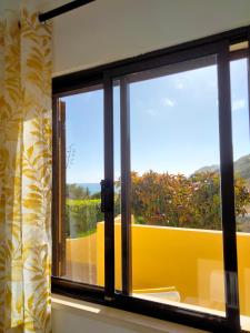 uma janela com vista para uma cerca amarela em Lovely 2-bedroom in Carvoeiro free parking em Poço Partido