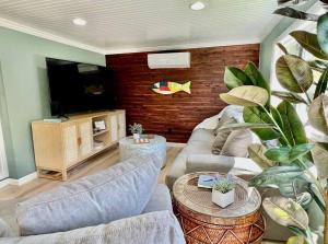 a living room with two couches and a flat screen tv at Sea la Vie - Beach Town Charm+Newly Renovated in Cocoa Beach