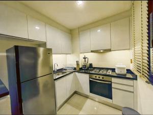 a kitchen with a stainless steel refrigerator and cabinets at Laguna Park, BangTao Laguna in Bang Tao Beach