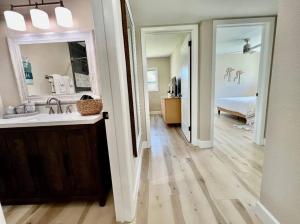 a bathroom with a sink and a mirror and a bedroom at Sea la Vie - Beach Town Charm+Newly Renovated in Cocoa Beach +43 photos