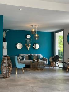 a living room with a couch and a blue wall at Hotel La Voile in Bormes-les-Mimosas