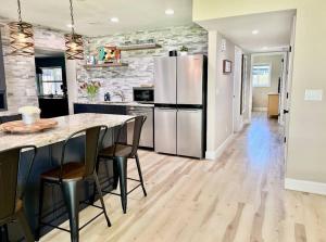 a kitchen with a refrigerator and a table with chairs at Sea la Vie - Beach Town Charm+Newly Renovated in Cocoa Beach