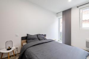 sypialnia z łóżkiem, stołem i oknami w obiekcie Idéal couples & pro - Patio extérieur- Proche centre ville et gare - Promenade au bord de la Charente - Parking à proximité - Wifi très haut debit - Équipement premium -Netflix w mieście Angoulême
