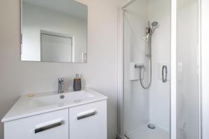 biała łazienka z umywalką i prysznicem w obiekcie Idéal couples & pro - Patio extérieur- Proche centre ville et gare - Promenade au bord de la Charente - Parking à proximité - Wifi très haut debit - Équipement premium -Netflix w mieście Angoulême