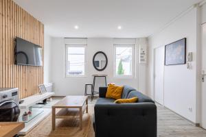 salon z kanapą i stołem w obiekcie Idéal couples & pro - Patio extérieur- Proche centre ville et gare - Promenade au bord de la Charente - Parking à proximité - Wifi très haut debit - Équipement premium -Netflix w mieście Angoulême
