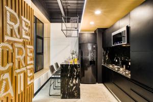 een keuken met een zwart aanrecht en een zwarte koelkast bij Downtown Designer Apartments by ULIV in Tijuana