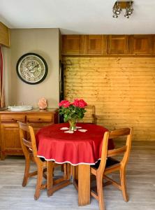 a dining room table with a vase of flowers on it at ANTONIA2 in Brides-les-Bains