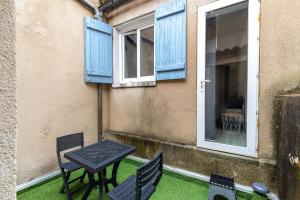 taras ze stołem, krzesłami i oknem w obiekcie Idéal couples & pro - Patio extérieur- Proche centre ville et gare - Promenade au bord de la Charente - Parking à proximité - Wifi très haut debit - Équipement premium -Netflix w mieście Angoulême +16 zdjęć