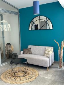 a living room with a couch and a blue wall at Hotel La Voile in Bormes-les-Mimosas
