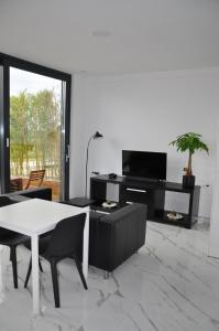 ein Wohnzimmer mit einem Tisch und einem TV in der Unterkunft Apartment Solis in Portorož