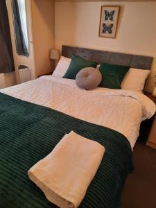 a bedroom with two beds with green and white sheets at 47R Place in Dagenham