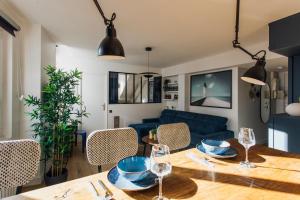 een woonkamer met een houten tafel en een blauwe bank bij Loge du Pré Carré - hypercentre in Annecy