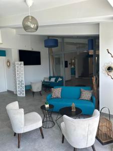 a living room with a blue couch and chairs at Hotel La Voile in Bormes-les-Mimosas
