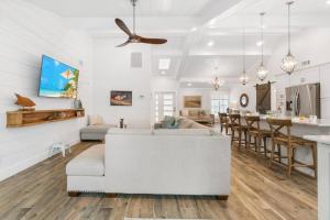 a white living room with a white couch and a kitchen at Tahiti Cottage in Marco Island +37 photos