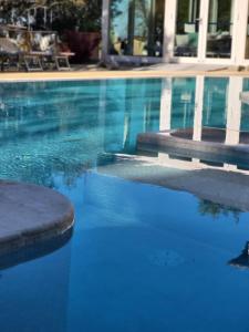 una piscina con acqua blu di fronte a un edificio di Cortona Resort & Spa a Cortona