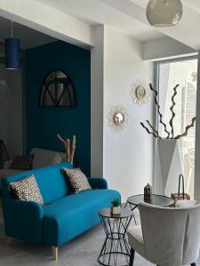 a living room with a blue couch and a table at Hotel La Voile in Bormes-les-Mimosas