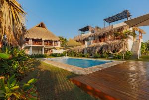 a resort with a swimming pool and a building at Ka´ana Surf in El Paredón Buena Vista
