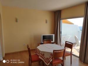 ein Esszimmer mit Tisch und Fernseher in der Unterkunft Excelente apartamento con esplédidas vistas al mar in Puerto de la Cruz