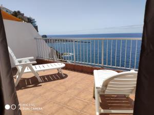 ein Balkon mit Stühlen und Blick auf das Meer in der Unterkunft Excelente apartamento con esplédidas vistas al mar in Puerto de la Cruz