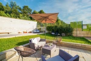 a patio with a couch and an umbrella at Magníficos Dias Atlânticos in Moledo