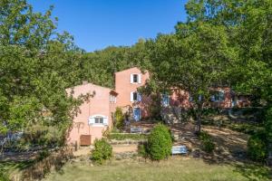 an exterior view of a pink house with trees at Villa Vauvert in Saignon