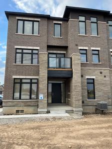 um grande edifício de tijolos com janelas pretas em Luxury Brand New Townhouse In Milton Ontario em Milton