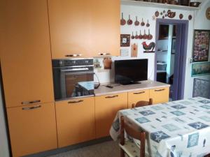 a kitchen with yellow cabinets and a stove and a table at casa miglio in Marina di Pietrasanta