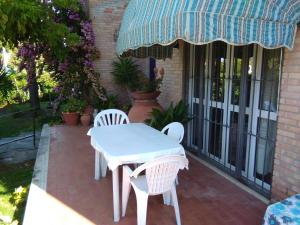 - une table et des chaises blanches sur la terrasse dans l'établissement casa miglio, à Marina di Pietrasanta