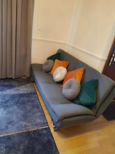 um sofá com almofadas num quarto em 47R Place em Dagenham