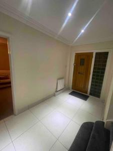 a living room with a couch and a wooden door at Lovely Detached house in lovely location in West Drayton