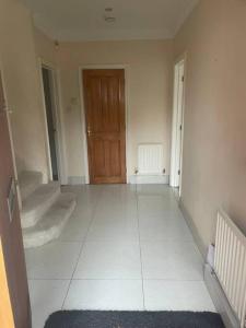 an empty room with a door and a white tile floor at Lovely Detached house in lovely location in West Drayton