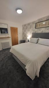 a large white bed in a bedroom with a television at The bolt in Newhaven