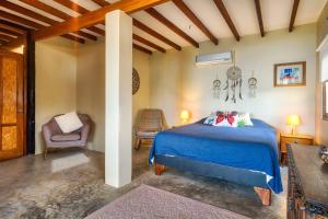 una camera con un letto blu e una sedia di Marmot Hill Apartment, loft for 2, Las Pocitas a Máncora