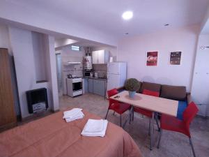 a kitchen and a living room with a table and chairs at Center Studio 3pax apartamento in Trelew