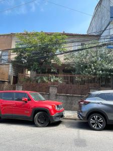 dos autos estacionados uno al lado del otro en una calle en I Love Rio Hostel, en Río de Janeiro