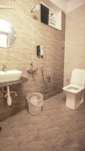 a bathroom with a toilet and a sink at Radhe Suites in Hyderabad +40 photos