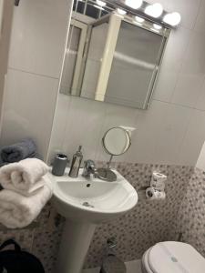 bagno con lavandino, specchio e servizi igienici di Rosina apartment a Torre del Greco